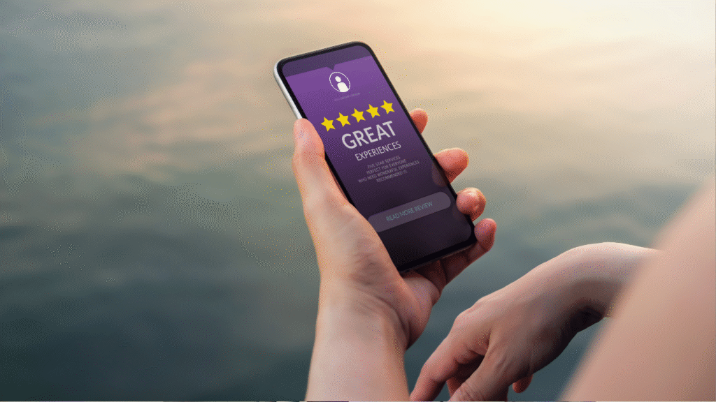 close-up of a person holding a smartphone displaying a 5-star business rating, representing the digital verification step of a modern referral.