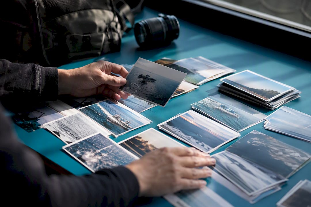 Hands sorting printed photos on table